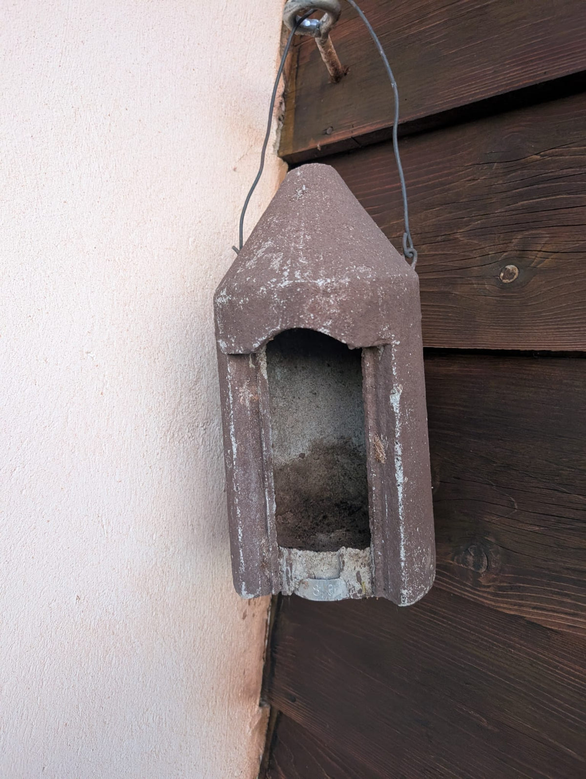 Schwegler Nistkasten aus Holzbeton, seit etwa 1980 im Garten – die Farbe blättert ab, das Material ist unversehrt